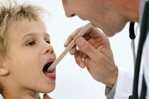 el médico examina la garganta de un niño con psoriasis